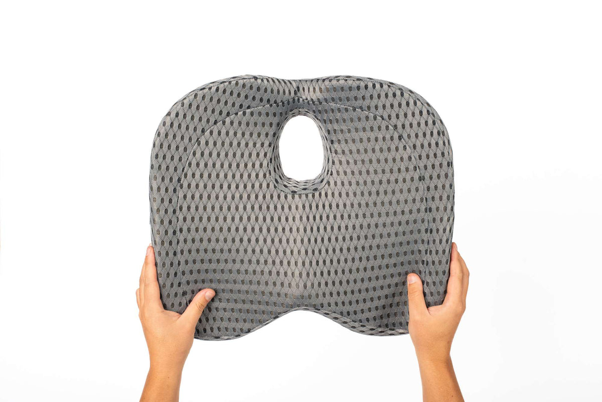 Two hands holding up the cushion to display its full size